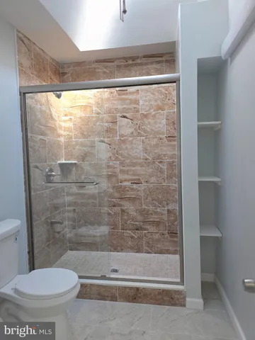 a bathroom with a shower a toilet and a sink