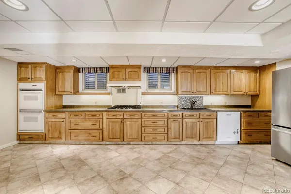 a kitchen with granite countertop a stove sink and cabinets