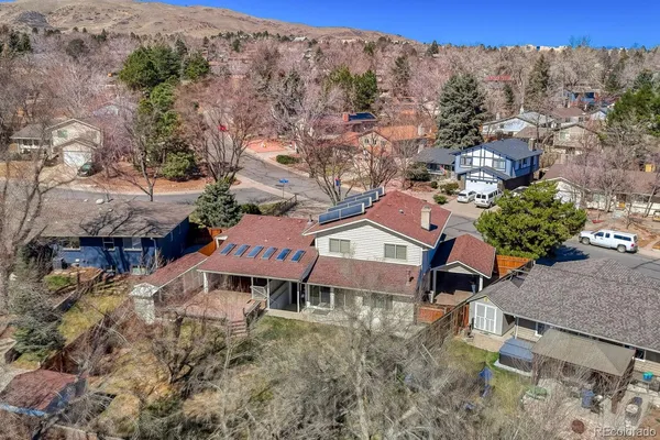 an aerial view of a house with a mountain