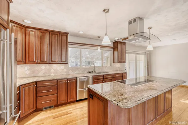 a kitchen with stainless steel appliances granite countertop stove top oven and cabinets