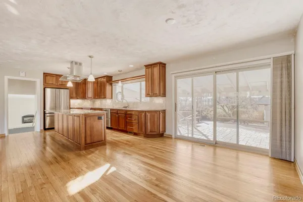 a large kitchen with stainless steel appliances wooden floors and white cabinets