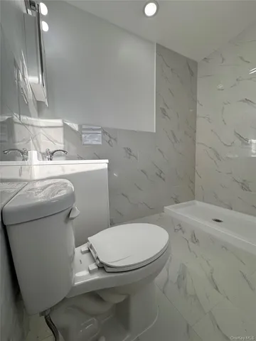 a white toilet sitting next to a bathroom sink and vanity