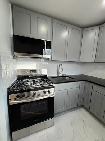 a kitchen with stainless steel appliances granite countertop a stove and a microwave