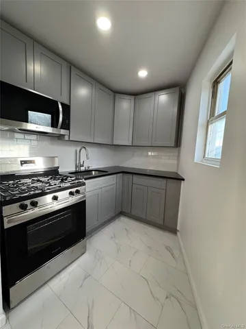 a kitchen with stainless steel appliances granite countertop a stove a sink and a refrigerator
