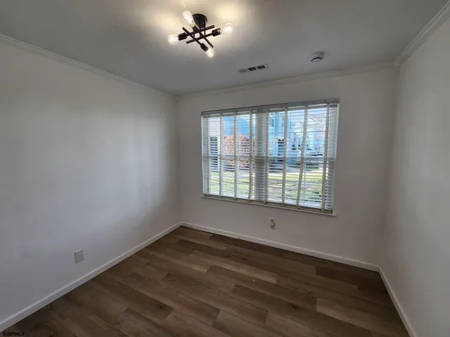 a view of a room with a window and wooden floor