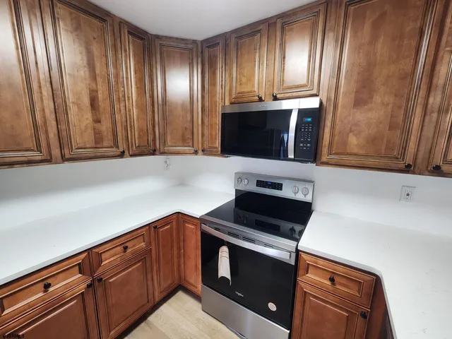 a kitchen with granite countertop cabinets stainless steel appliances and a window