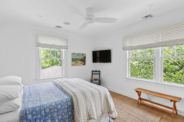 a bedroom with a bed and a flat tv screen on the dresser