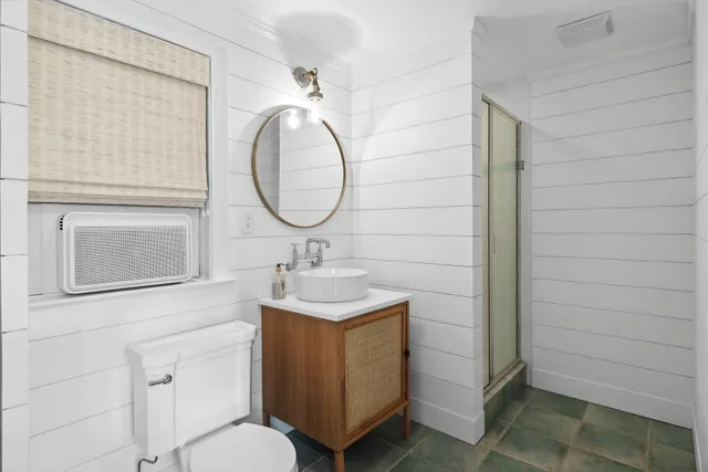 a bathroom with a toilet sink vanity and mirror