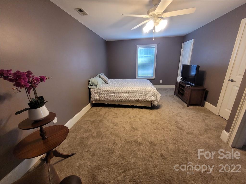 679 Presbyterian Road Mooresville, NC 28115 - Photo 15 of 25 a bedroom with a bed and a chandelier