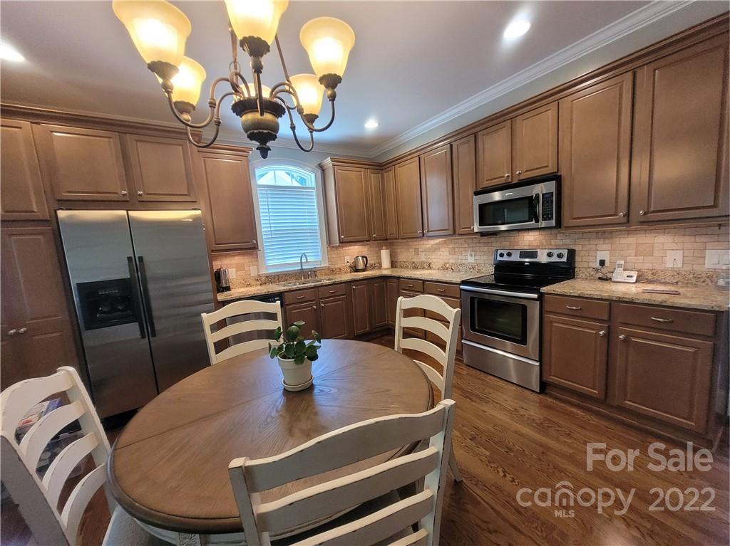 679 Presbyterian Road Mooresville, NC 28115 - Photo 4 of 25 a kitchen with stainless steel appliances granite countertop a sink a stove top oven a granite counter space and cabinets