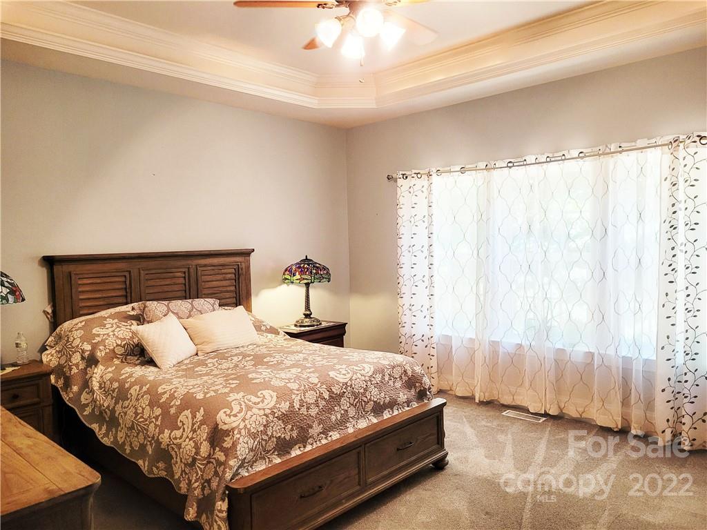 679 Presbyterian Road Mooresville, NC 28115 - Photo 7 of 25 a bedroom with a bed and a chandelier