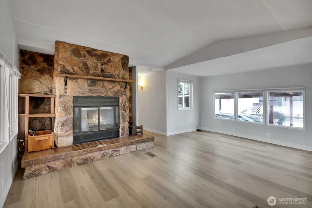 an empty room with windows and fireplace