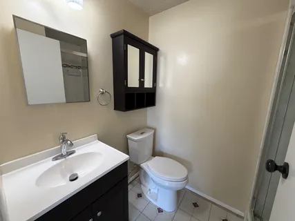a bathroom with a toilet sink and mirror