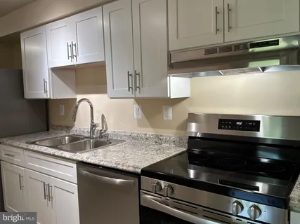 a kitchen with granite countertop a stove and a sink