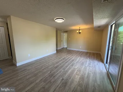an empty room with wooden floor and a fireplace