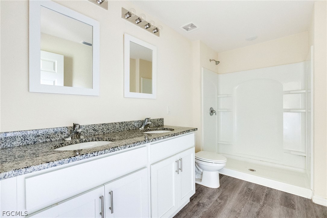 1405 Inwood Road LaBelle, FL 33935 - Photo 17 of 35 a bathroom with a granite countertop sink a toilet and shower