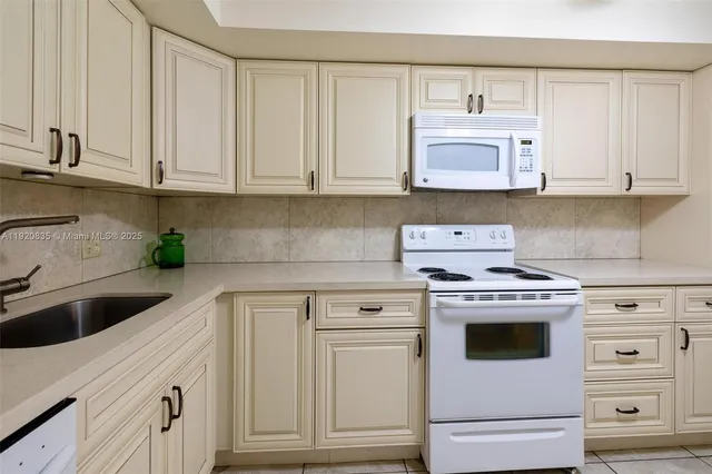 a kitchen with white cabinets and white appliances
