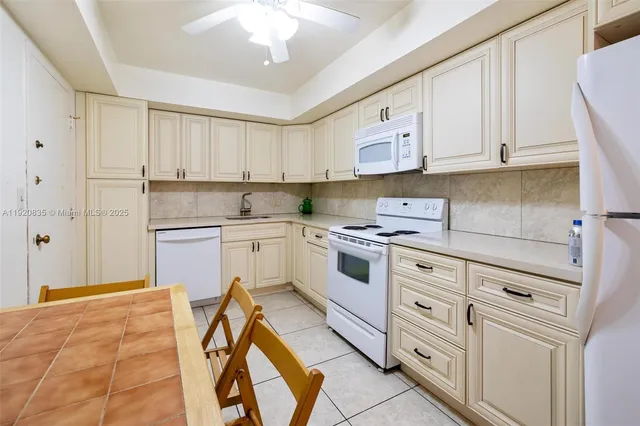 a kitchen with white cabinets appliances and a sink