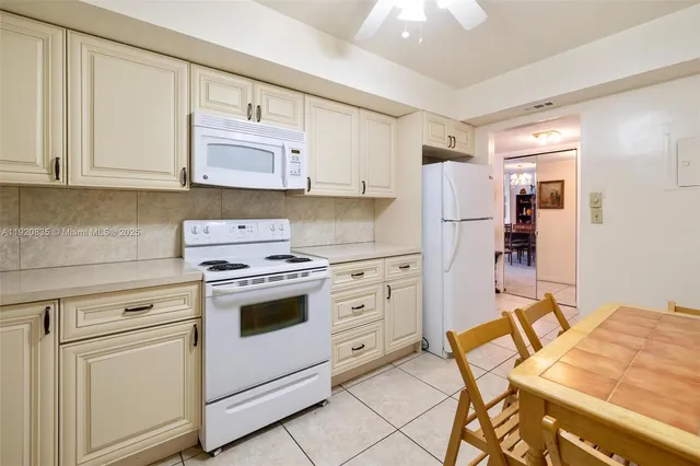 a kitchen with white cabinets and white appliances