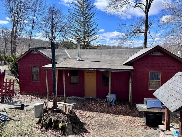 a couple of table and chairs in front of house