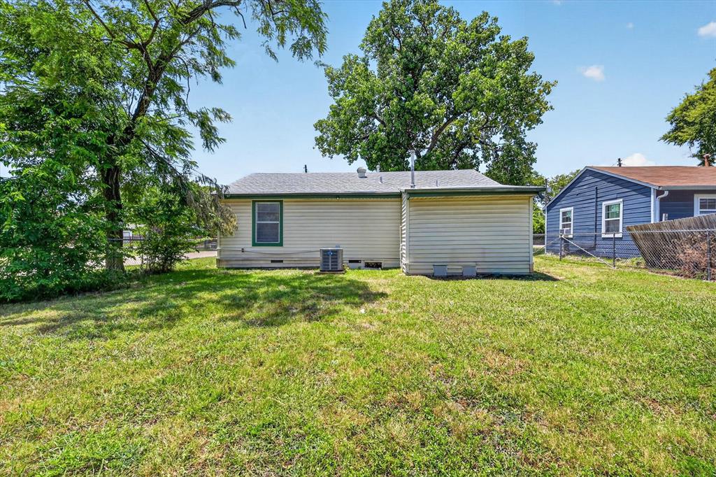 4450 Percy Street Lancaster, TX 75134 - Photo 17 of 18 Rear exterior featuring cream siding, green trim, a single window, and a visible HVAC unit
