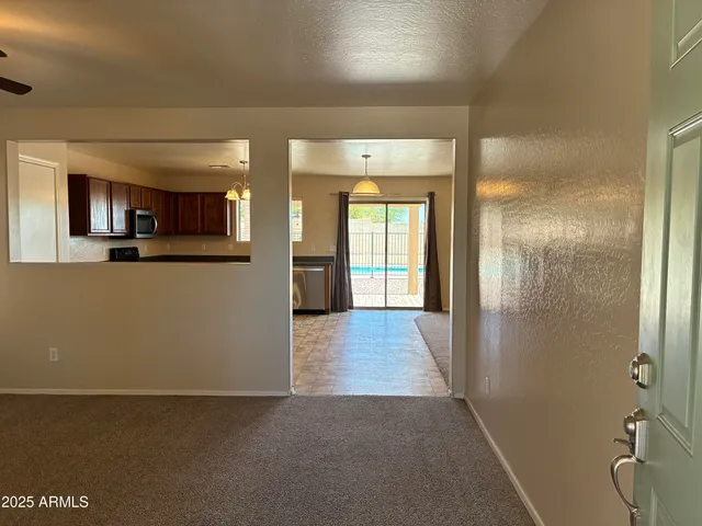 a view of a hallway to a livingroom with furniture