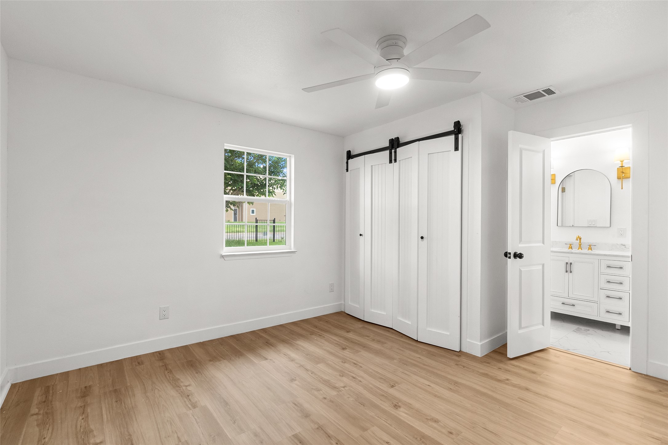 409 Ave R Marble Falls, TX 78654 - Photo 17 of 25 Room featuring wood-finish flooring, a white ceiling fan, and a window providing natural light