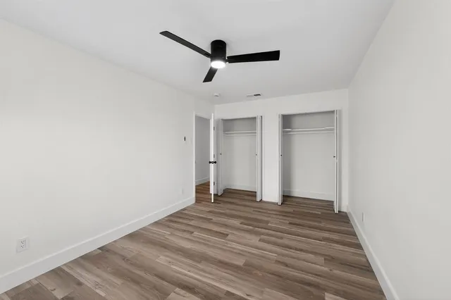 a view of empty room with wooden floor
