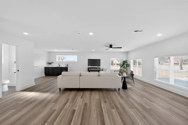 a living room with furniture and a wooden floor
