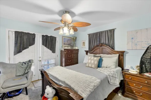 a bedroom with a bed a chandelier and dresser