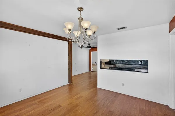 a view of a room with wooden floor and chandelier