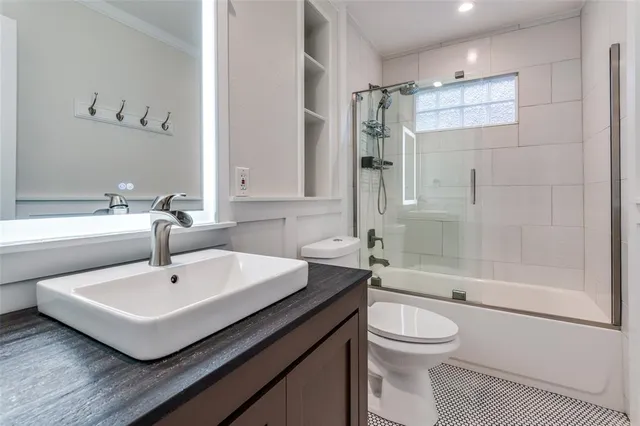 a bathroom with a sink toilet a mirror and shower