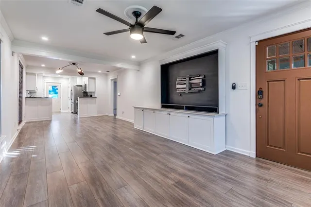 a view of a living room hardwood floor and a ceiling fan