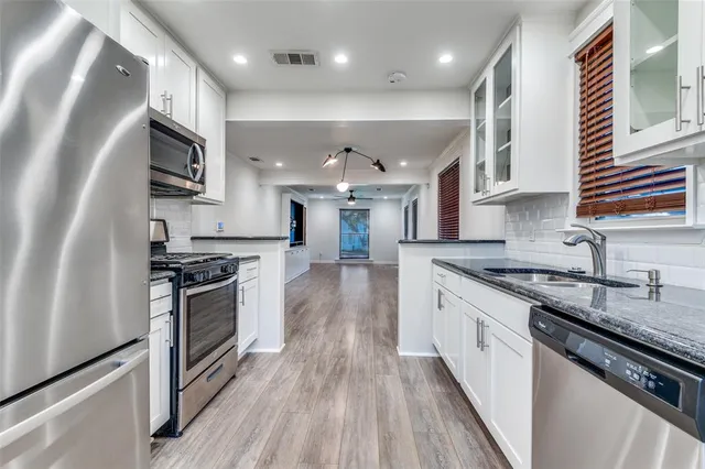 a kitchen with stainless steel appliances granite countertop a sink stove and refrigerator
