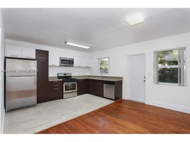 a kitchen with granite countertop a refrigerator and a stove