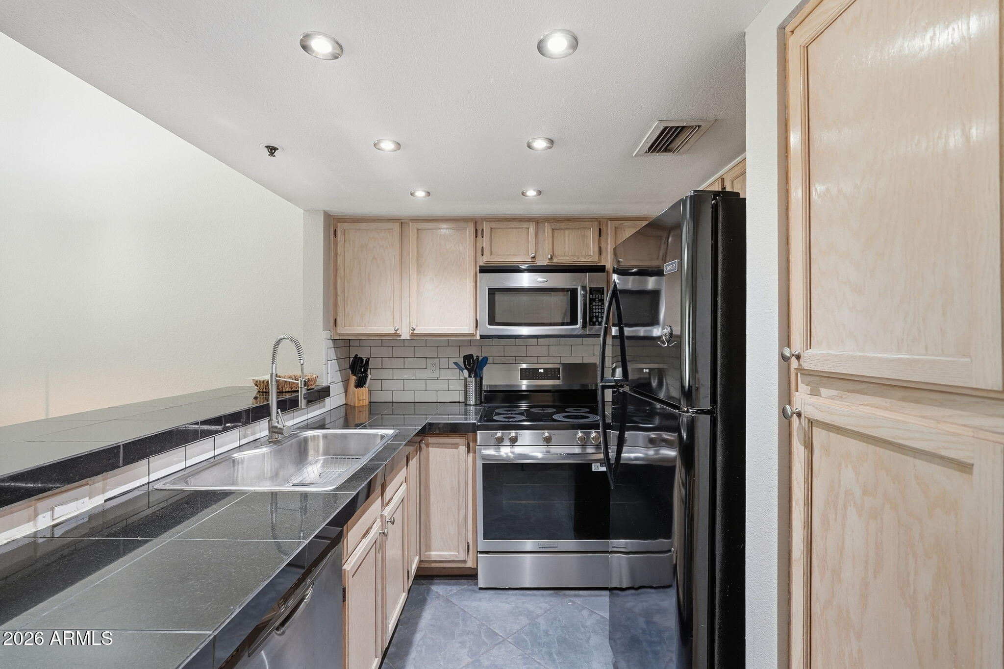 100 East Fillmore Street, Unit 216 Phoenix, AZ 85004 - Photo 3 of 36 a kitchen with stainless steel appliances granite countertop a sink stove and refrigerator