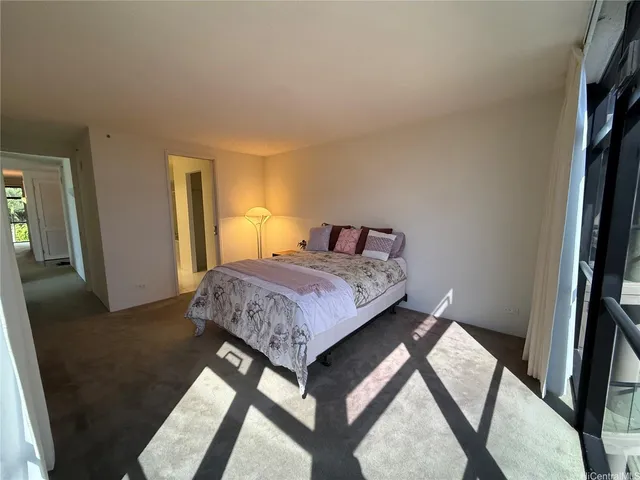 a bedroom with a bed and a flat tv screen on a dresser