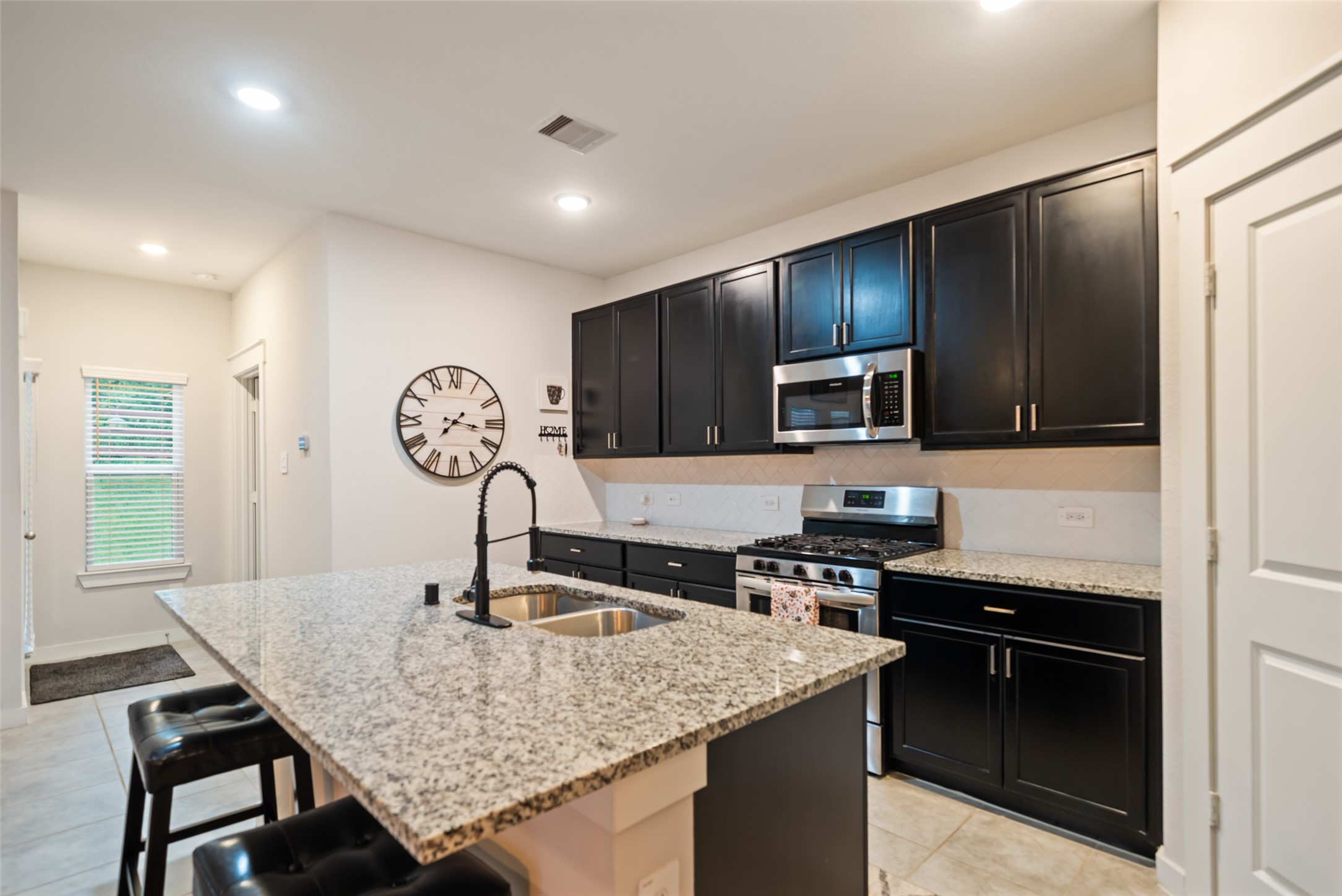 12158 Mustang Avenue Willis, TX 77378 - Photo 16 of 36 a kitchen with stainless steel appliances granite countertop a sink and a stove top oven with wooden floor