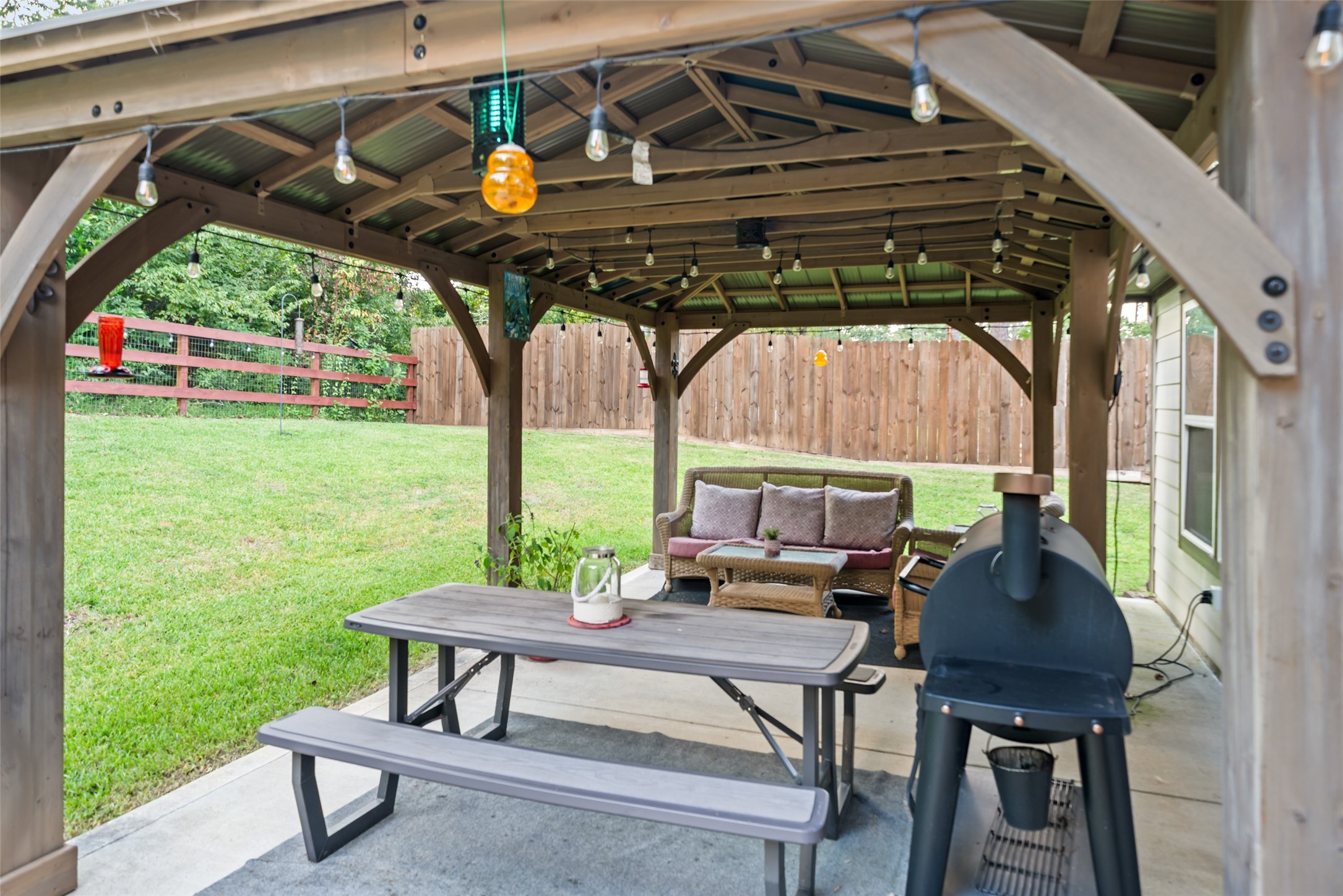 12158 Mustang Avenue Willis, TX 77378 - Photo 3 of 36 a view of a patio with table and chairs with wooden floor and fence