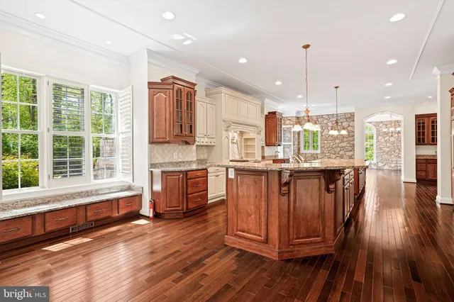 a kitchen with stainless steel appliances granite countertop a stove and a wooden floors