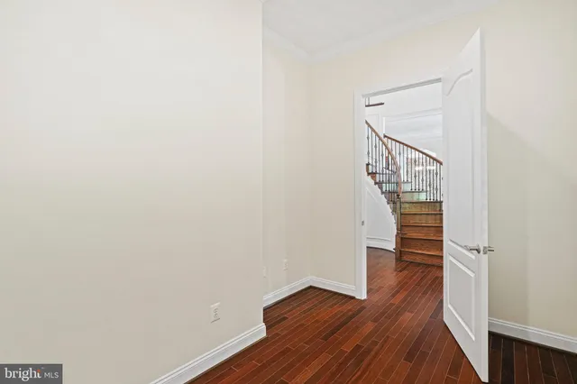 an empty room with wooden floor fireplace and windows