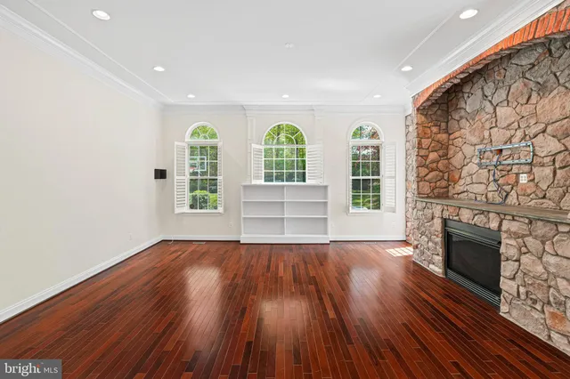 a view of a big room with wooden floor and windows