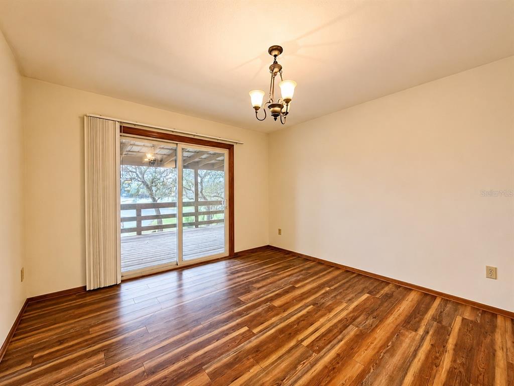 7119 Immokalee Road Keystone Heights, FL 32656 - Photo 12 of 50 a view of empty room with wooden floor and fan