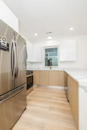 a large kitchen with stainless steel appliances wooden floor and a counter top space