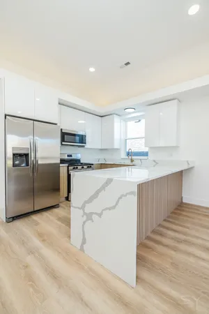 a kitchen with stainless steel appliances granite countertop a sink and a refrigerator
