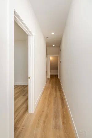 a view of hallway with wooden floor