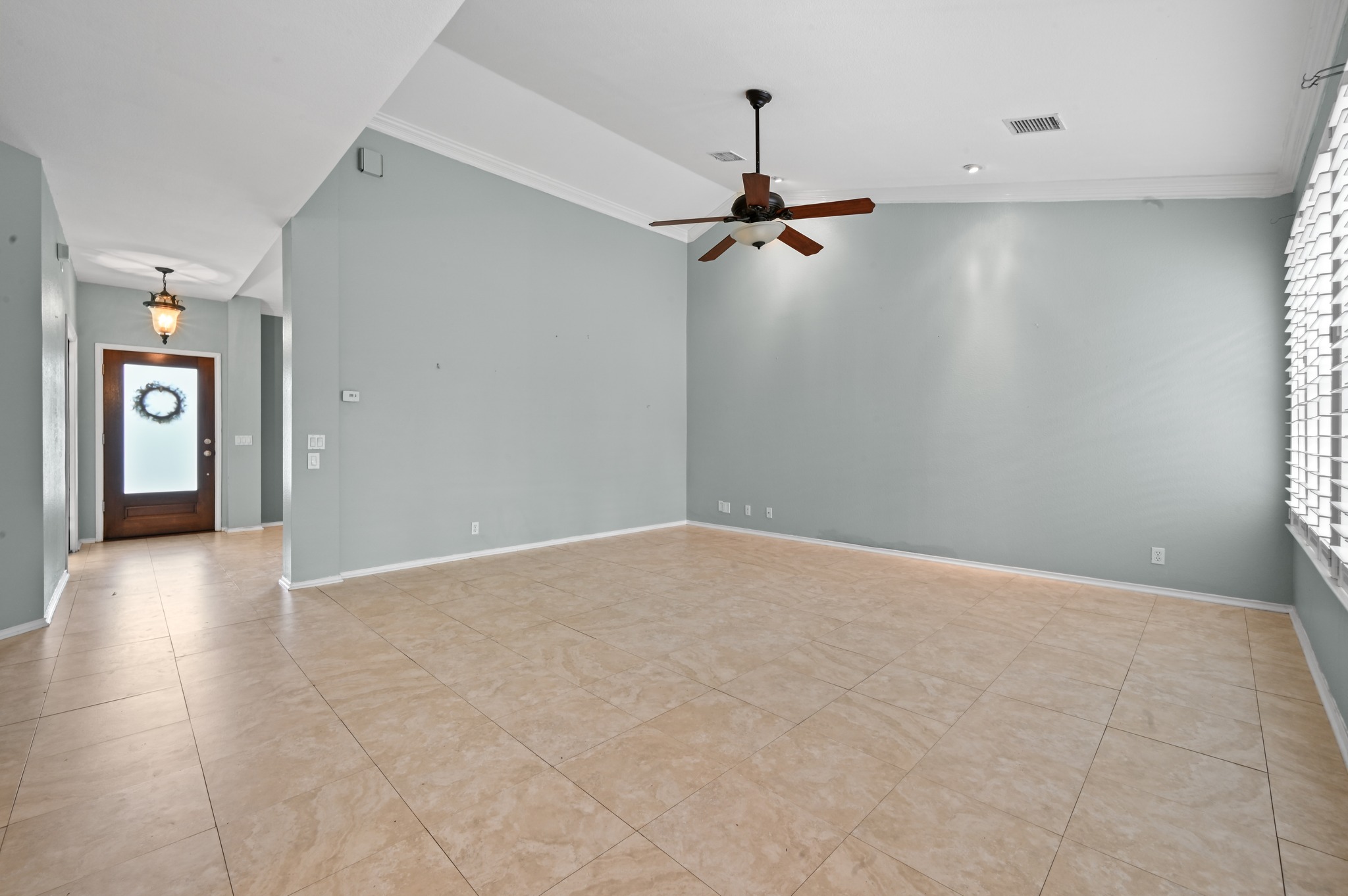 5313 Moon Shadow Drive Austin, TX 78735 - Photo 14 of 30 Spacious living area featuring large format tile flooring, crown molding, and a ceiling fan with integrated lighting
