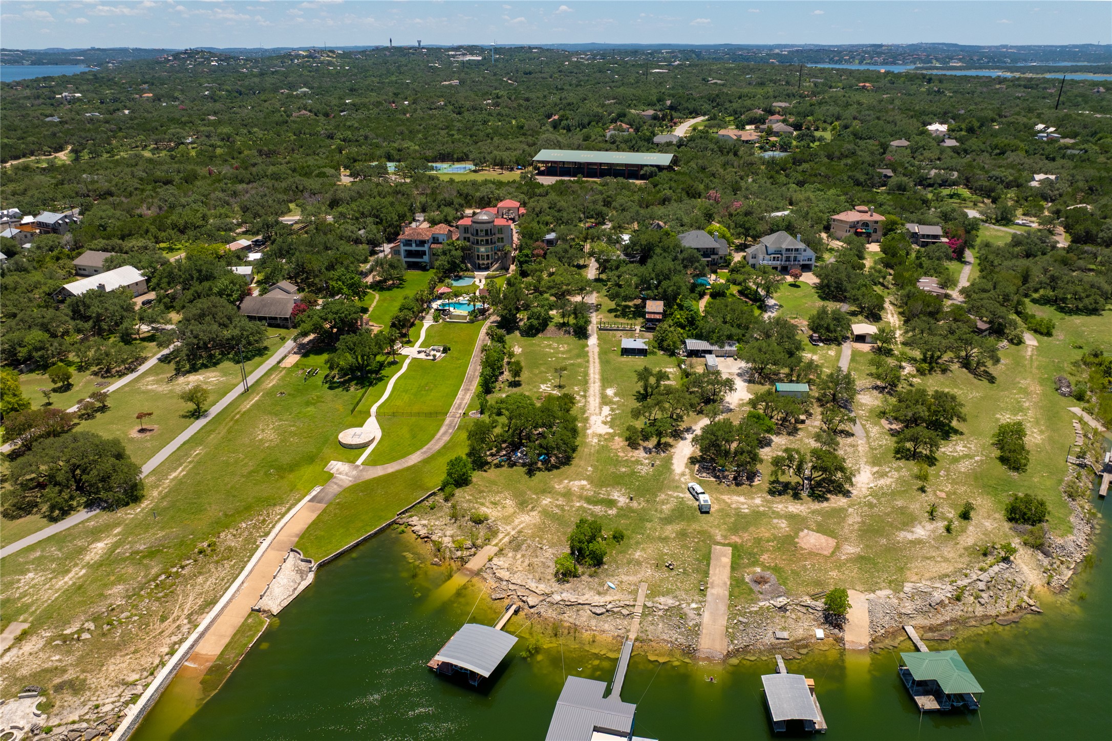 16800 Forest Way Austin, TX 78734 - Photo 11 of 15 An aerial panorama reveals a vast waterfront property featuring multiple boat docks and lush green landscaping.
