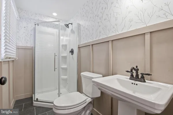 a bathroom with a sink a toilet and shower