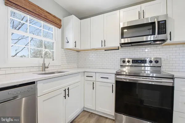 a kitchen with stainless steel appliances granite countertop a sink and a microwave